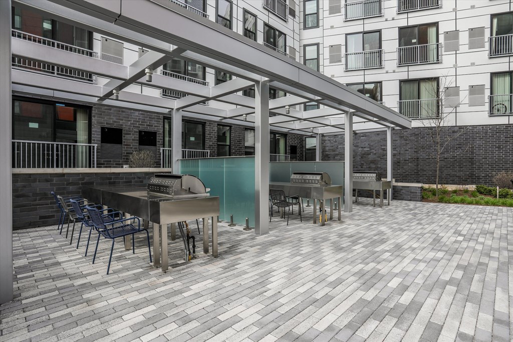 a patio with tables and chairs and a bar and grill in front of a building a patio with tables and chairs and a bar and grill in front of a building at Beekman on Broadway, Ann Arbor, Michigan
